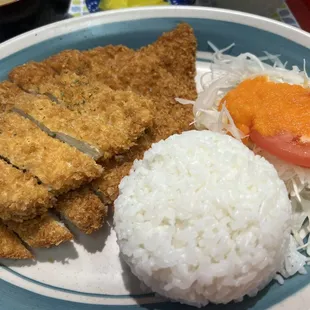 a plate of rice, meat, and vegetables