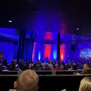 a crowd of people sitting in front of a stage