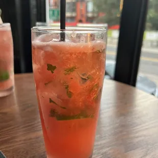 a glass of watermelon drink on a table