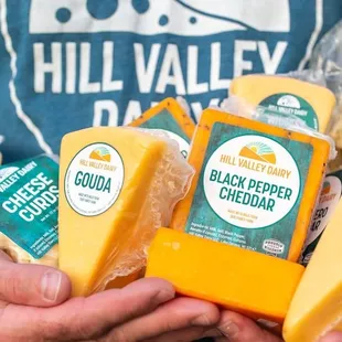 a man holding cheeses