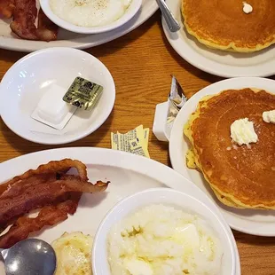a breakfast of pancakes, eggs, bacon, and hash browns