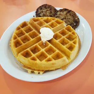 a plate of waffles with whipped cream