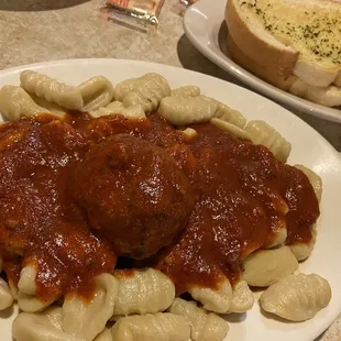 a plate of pasta with meatballs and bread