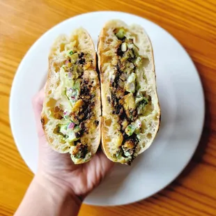 a hand holding a sandwich