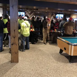 a pool table and a crowd of people