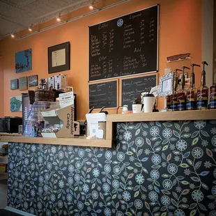 a bar with a chalkboard menu on the wall