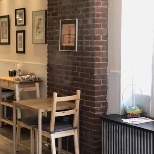 a table and chairs in front of a brick wall