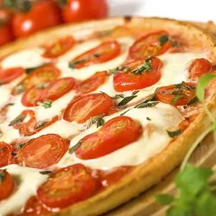 a pizza with tomatoes and basil
