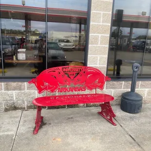 a red bench in front of a store