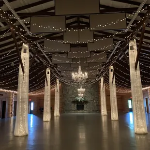 A full view of the hall with fabric draping, three chandeliers and flower arrangement.  Fabric and chandeliers supplies and set up by Kevin.