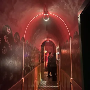 two people walking down a long hallway