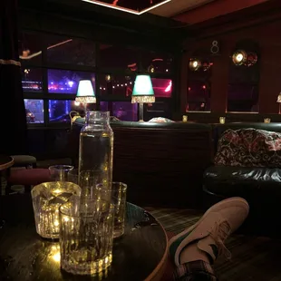 a glass of water on a table in a dimly lit room