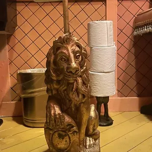 a lion toilet paper holder with a roll of toilet paper