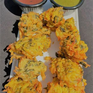 a plate of food with dipping sauces