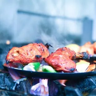 chicken and vegetables cooking on a grill