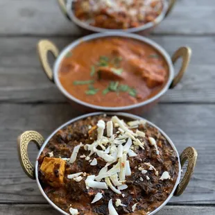 three bowls of food on a wooden table