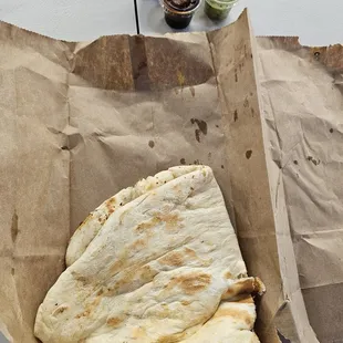 Garlic Naan bread was presented in a brown paper bag and folded in half. Two dipping sauces: balsamic vinegar and an herbal, spicy sauce