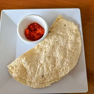 a tortilla and a bowl of salsa