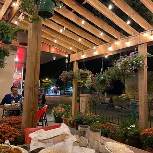 a person eating a meal under a pergol roof