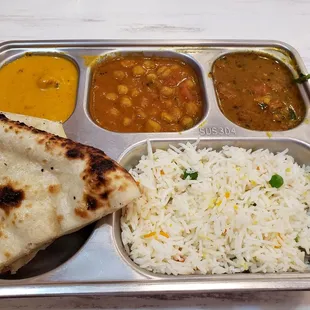 a tray of food including rice, naan and curry