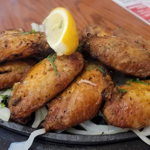 a plate of chicken wings and onions