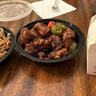 two bowls of noodles and a take out box