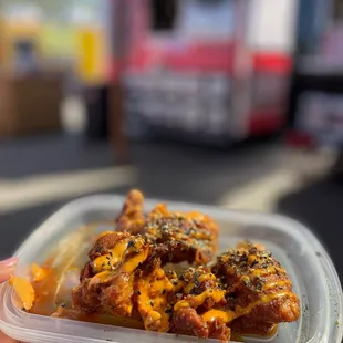 a hand holding a container of food