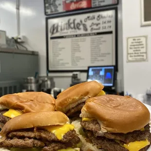 a hand holding a plate of sandwiches