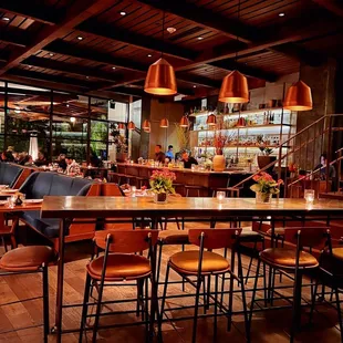 a dining area with a bar and chairs