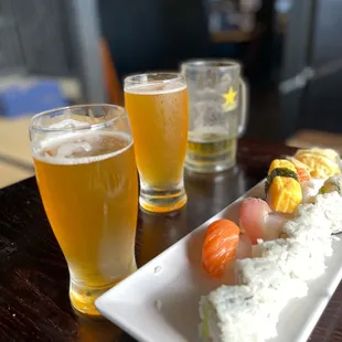 a plate of sushi and a glass of beer