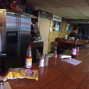 You are looking at the entire place in this shot. It contains a small bar with a few seats and a very small dining area.