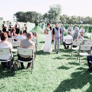 a bride and groom walking down the aisle