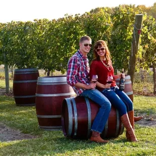 a couple sitting on a barrel