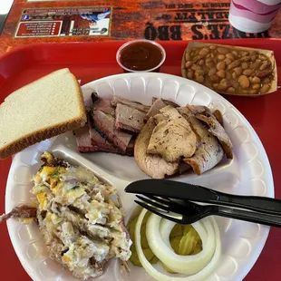 Brisket and smoked turkey with potato casserole and pinto beans.