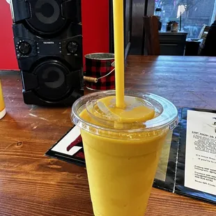 a smoothie in a plastic cup with a straw