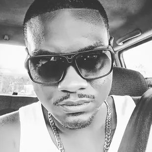 a man wearing sunglasses and a white tank top