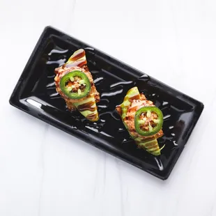 two pieces of food on a black plate