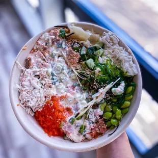 a hand holding a bowl of food