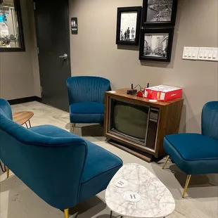 a living room with blue chairs and a television