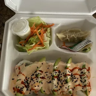 a plastic container with a salad and sauce