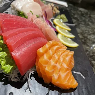 a variety of sushi on a black plate