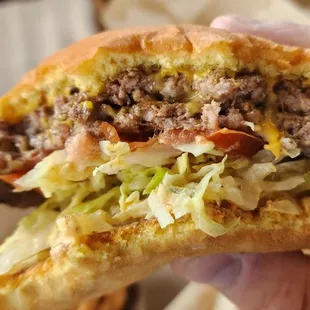 a hand holding a half eaten sandwich