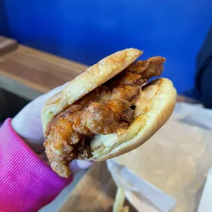 a hand holding a half eaten sandwich