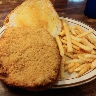 Large breaded tenderloin with fries.