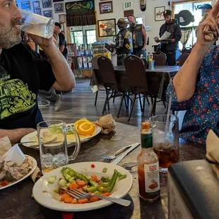 a man and a woman sitting at a table with plates of food