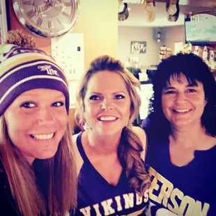 three smiling women in a bar