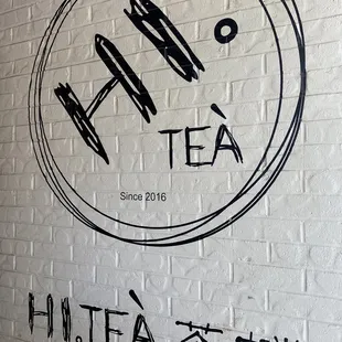 a black and white sign on a brick wall