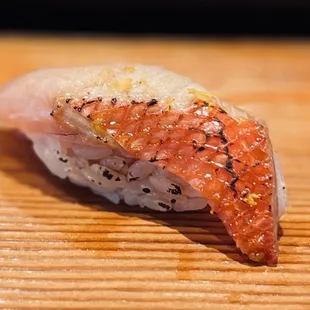 a piece of sushi on a wooden table