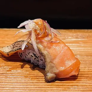 a piece of sushi on a wooden table