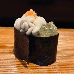 a piece of sushi on a wooden table